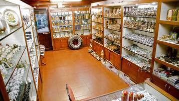A jewelry store with glass display cases and wooden shelves filled with various items.