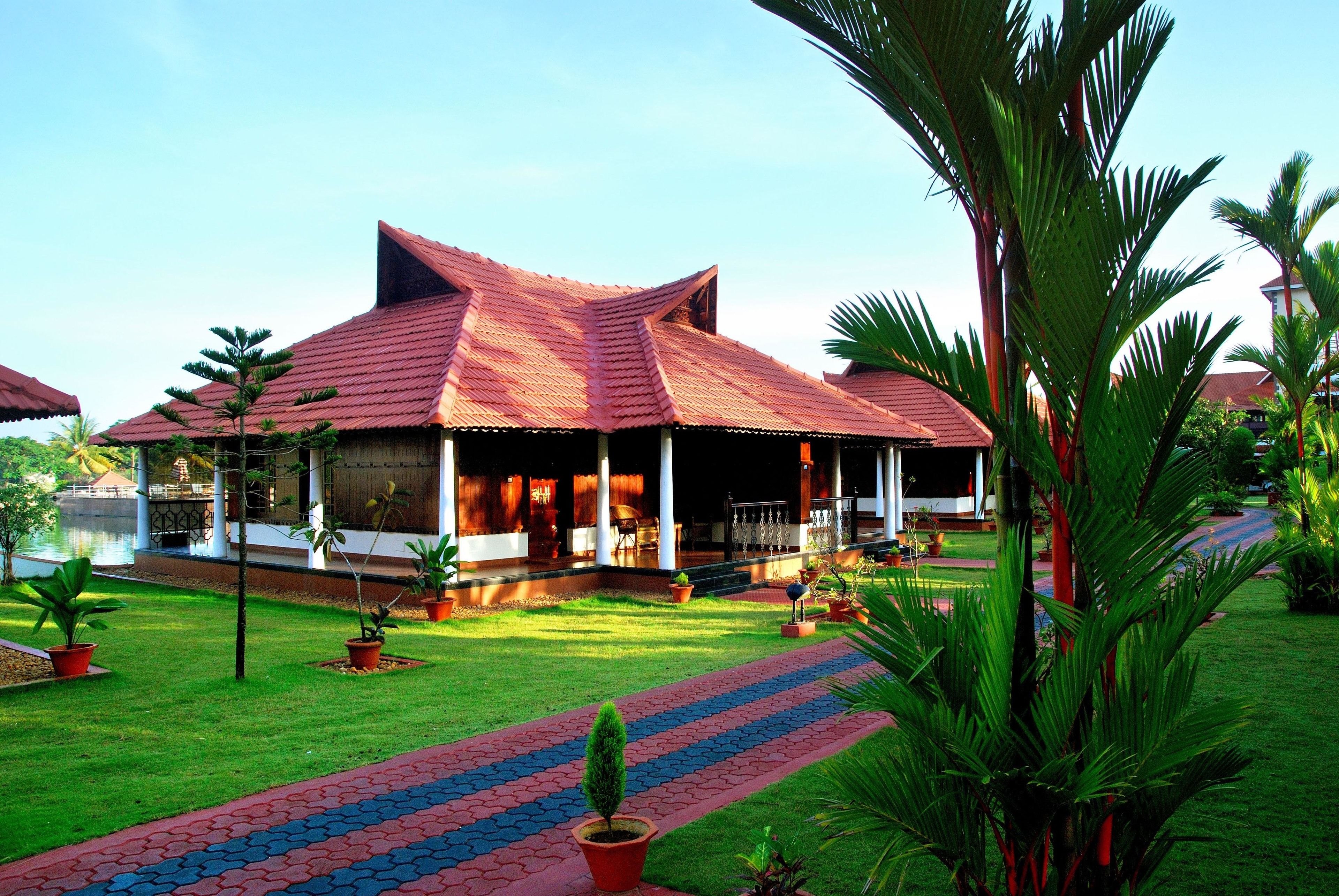 A traditional building with a tiled roof, surrounded by a well-maintained lawn and potted plants.