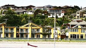 Una zona costera con casas amarillas y un barco amarrado cerca de la orilla.