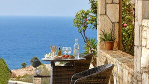 Una mesa servida con comida y bebidas, con vista al mar.