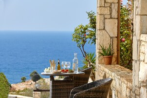 Ένα τραπέζι στρωμένο με φαγητά και ποτά, με θέα τη θάλασσα.