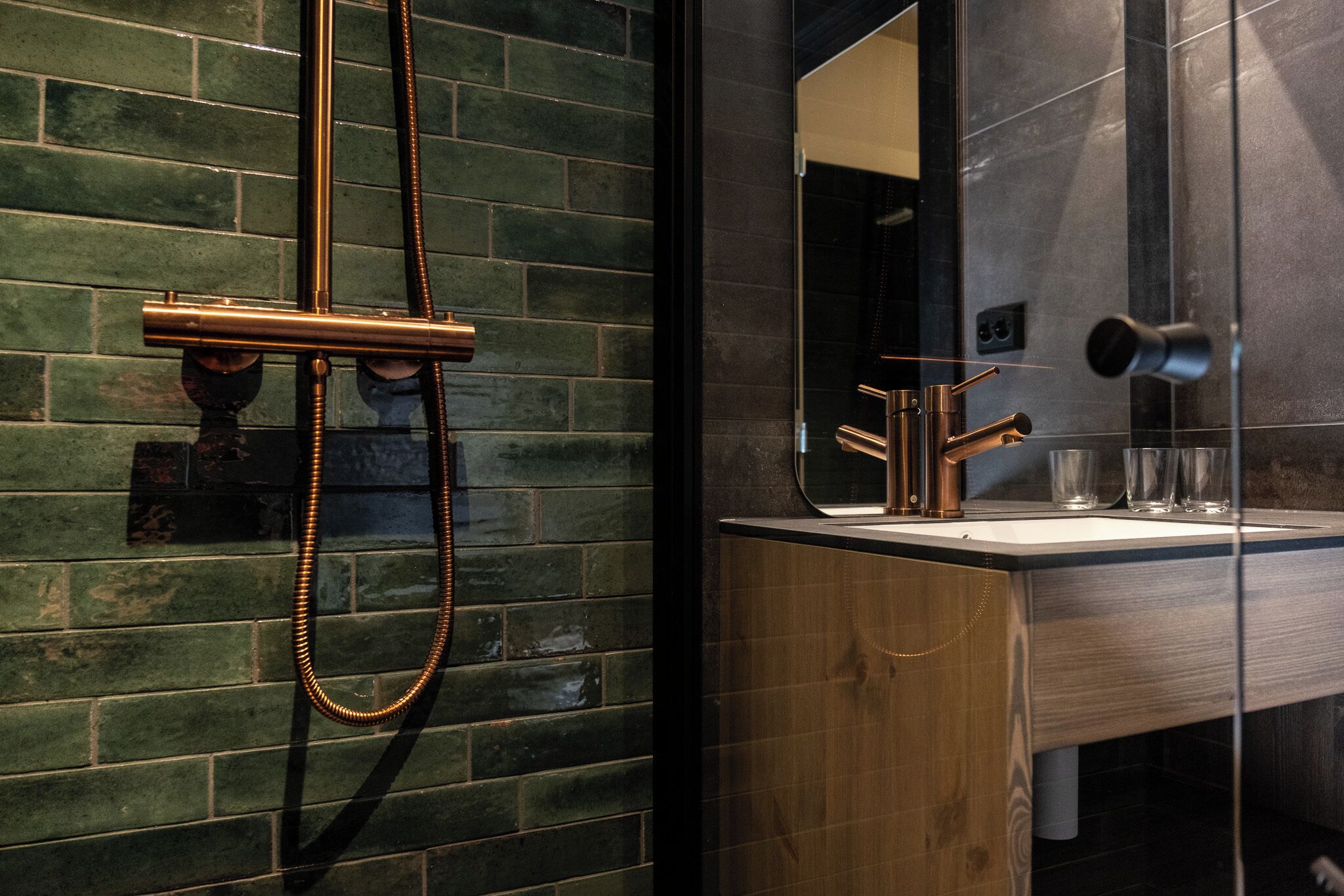 A bathroom with a wooden vanity, a glass shower enclosure, and a mirror with a towel rack.