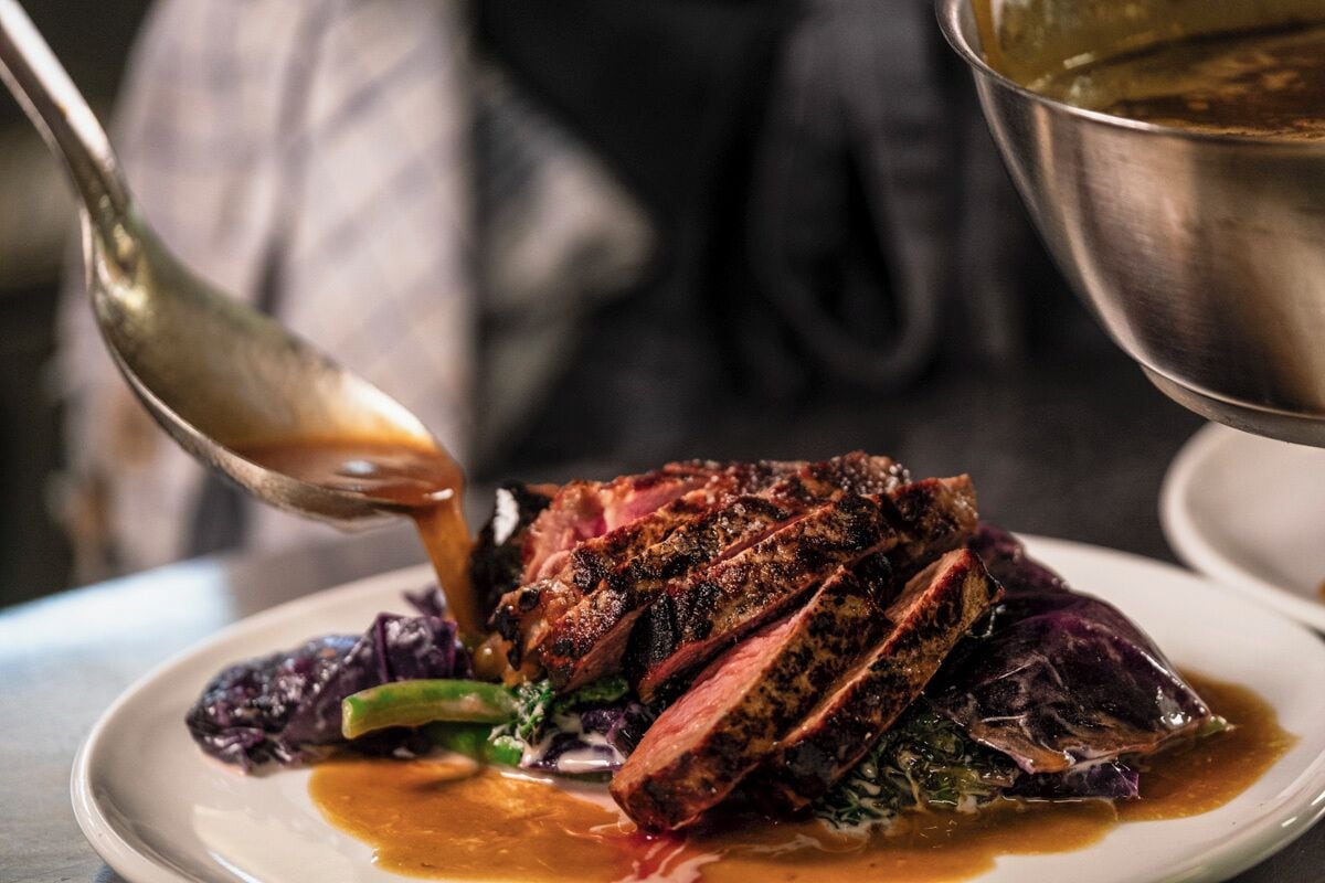 A plate of food with a steak and vegetables.