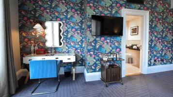 Relax in a stylish room with a vibrant floral design, flat-screen TV, and kitchenette.