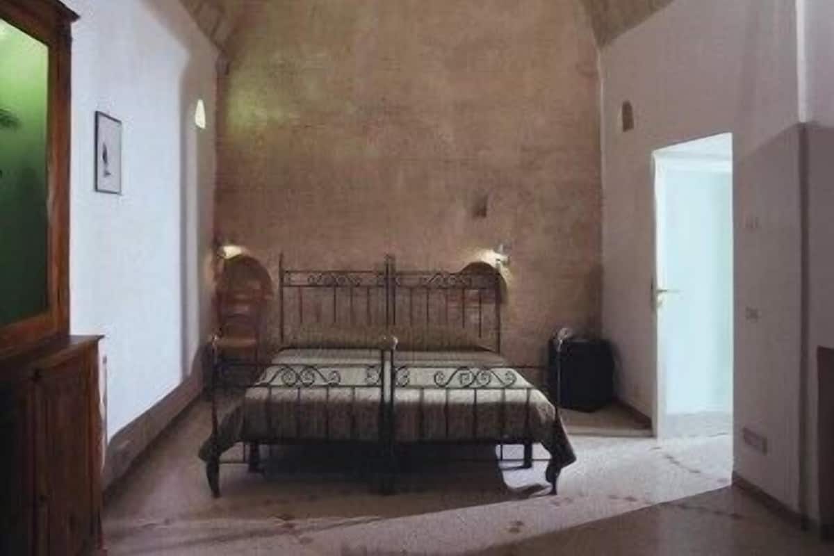 Un dormitorio con una cama, un armario de madera y una puerta.