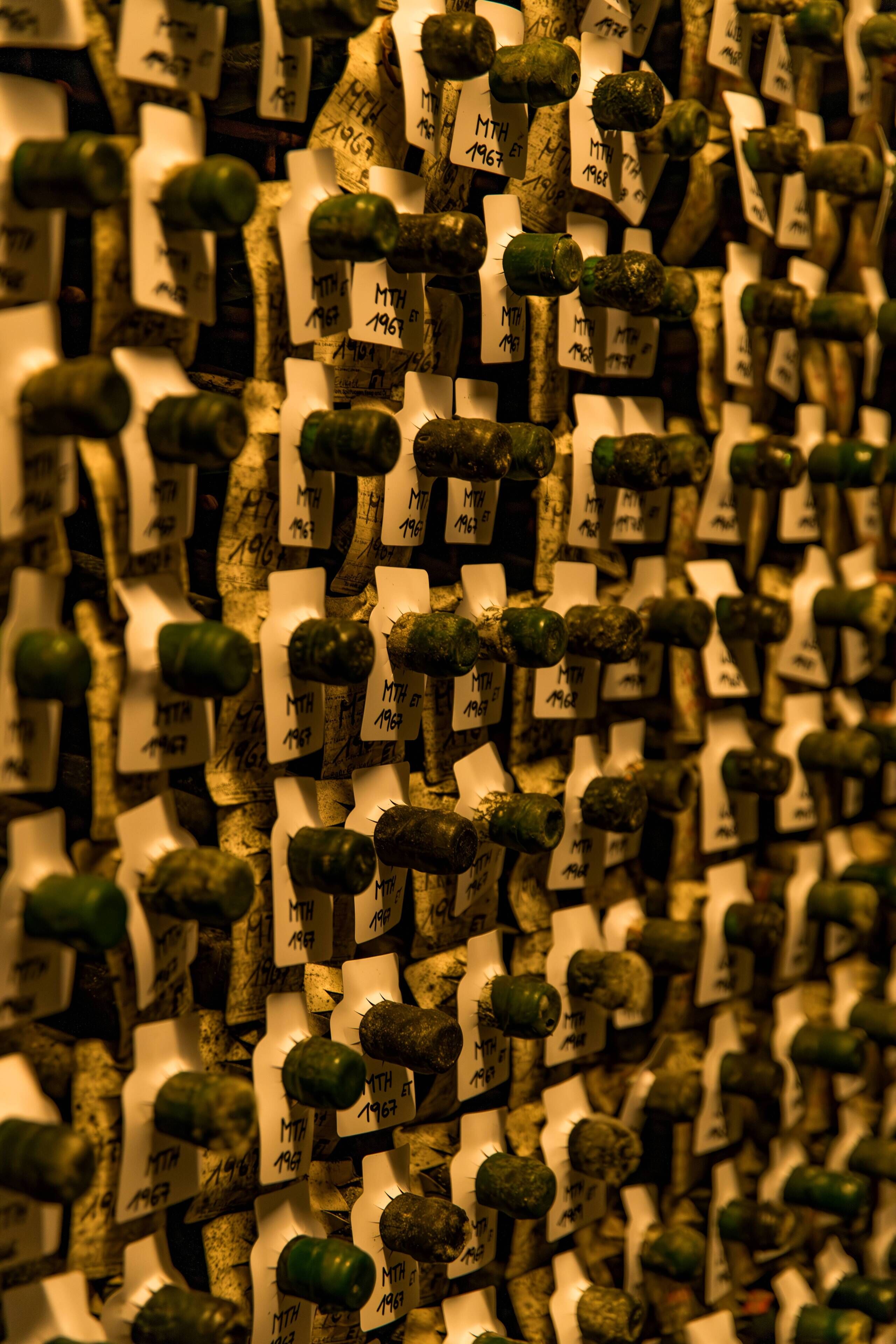 A wall of corks with labels, likely indicating a wine cellar or storage area.