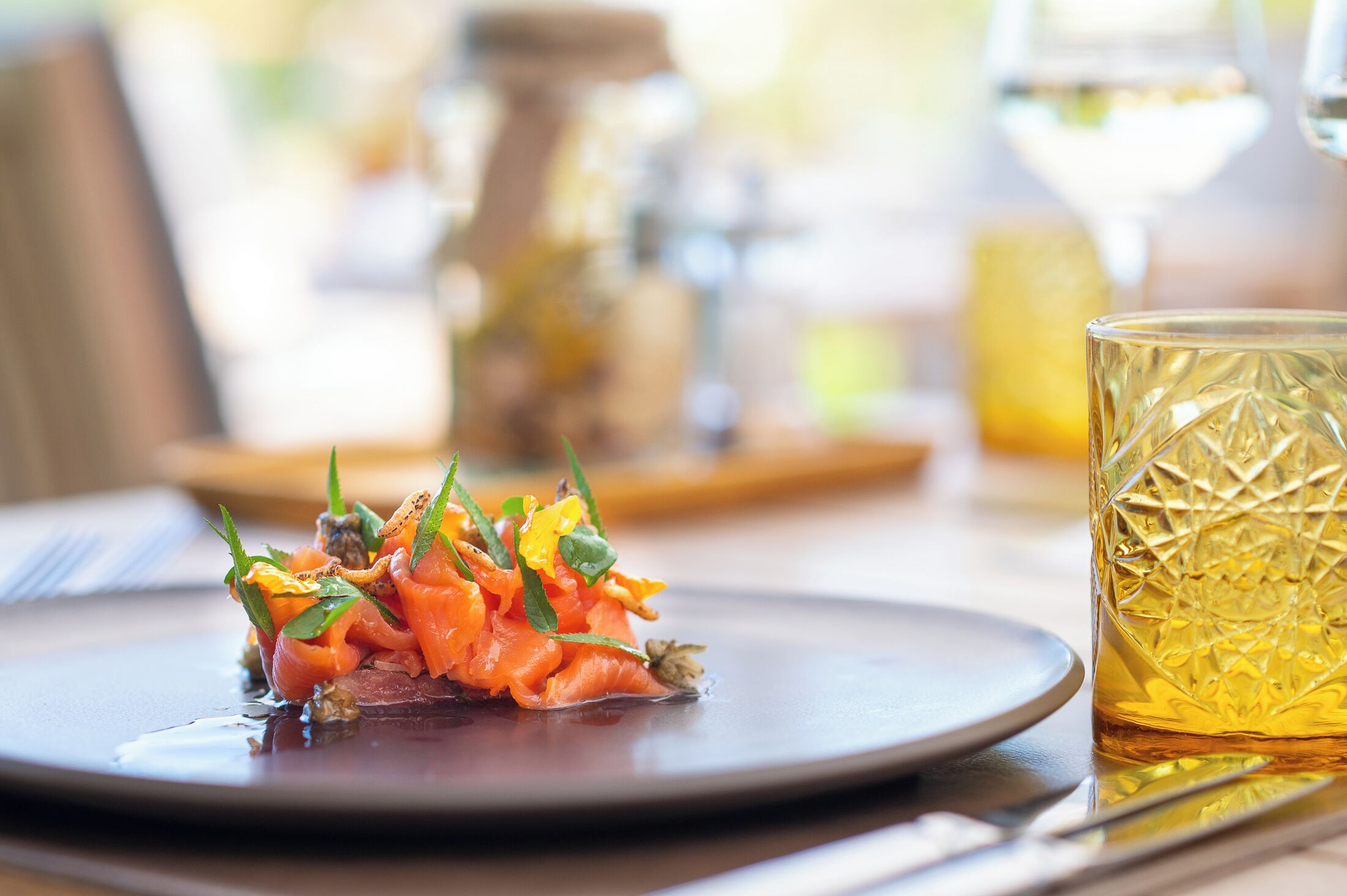 A plate of food with a glass of amber-colored beverage.