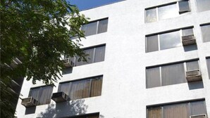 Un edificio di un hotel con numerosi balconi, bandiere e un cartello che indica che si tratta di un albergo.