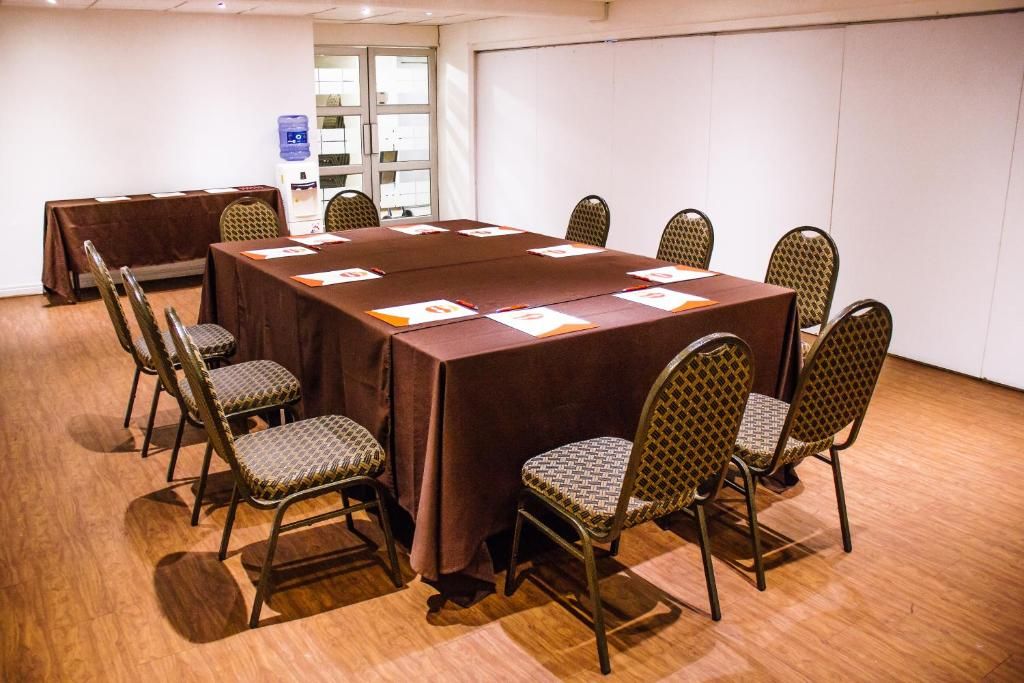 A conference room with a long table, eight chairs, and a water dispenser.