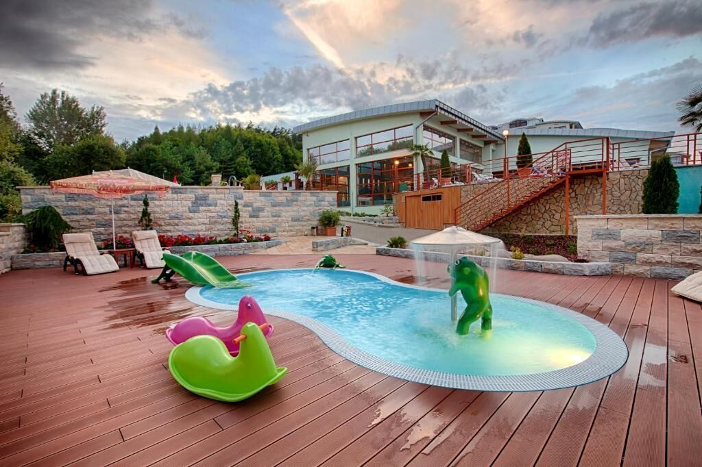 A swimming pool with slides and a deck area.