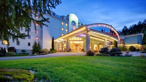 A hotel with a large entrance, a dome-shaped building, and a well-maintained lawn.