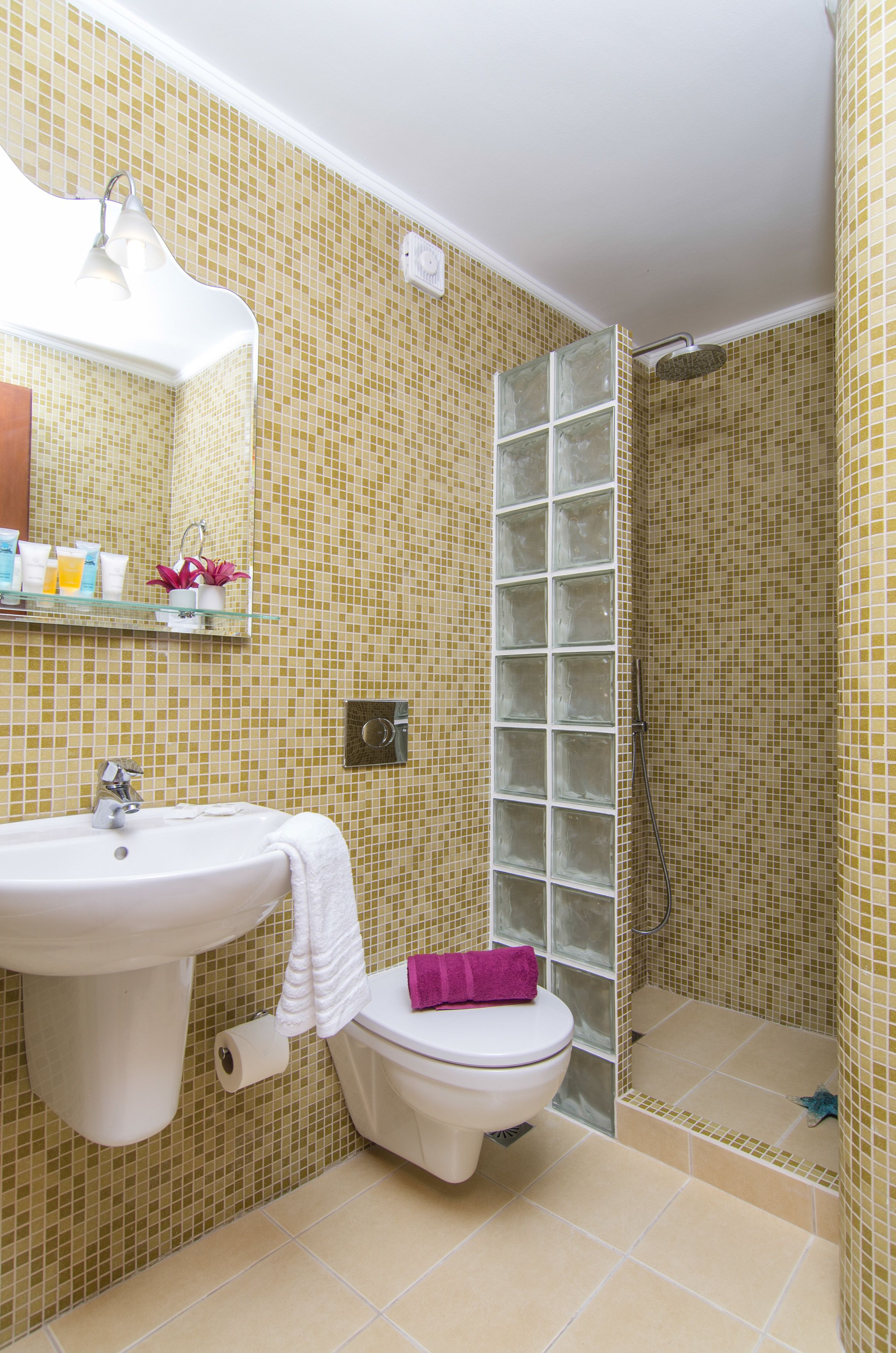 A bathroom with a sink, toilet, and shower.