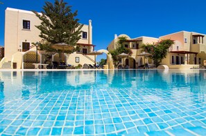 Una piscina al aire libre de temporada, sombrillas, tumbonas