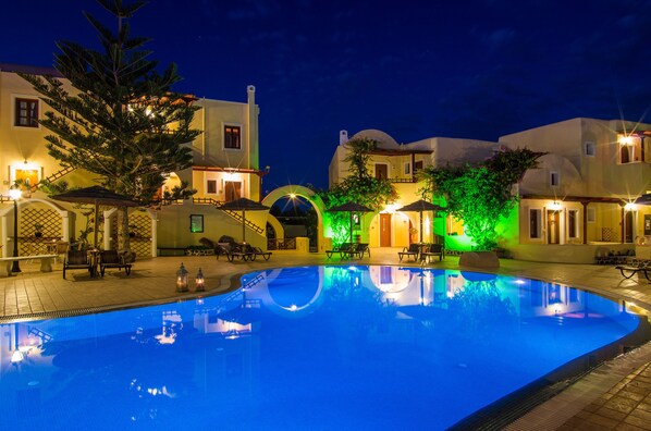 Una piscina al aire libre, sombrillas, tumbonas