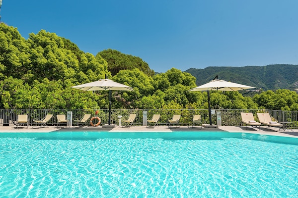 Piscina a l'aire lliure, para-sols i gandules