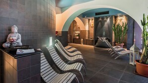 Een wellnessruimte met een receptiebalie, zitplaatsen en een Boeddhabeeld.