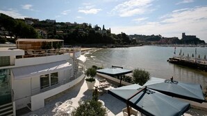 Une terrasse en bord de mer avec des places assises extérieures et une vue sur l’eau.