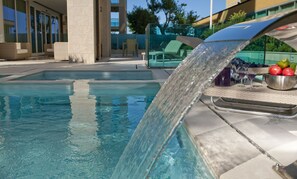 Piscine extérieure en saison, chaises longues