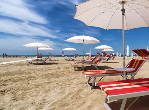 In Strandnähe, Liegestühle, Sonnenschirme, Strandtücher