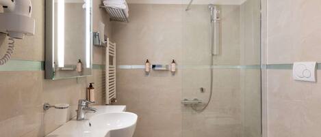 A modern bathroom with a glass-enclosed shower, a vanity with a sink, and a toilet.