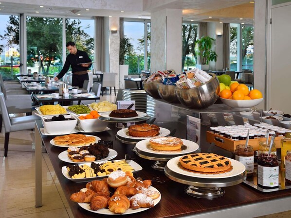 A buffet with various food items, including fruits, pastries, and desserts. - Mercure Rimini Artis (Rimini)