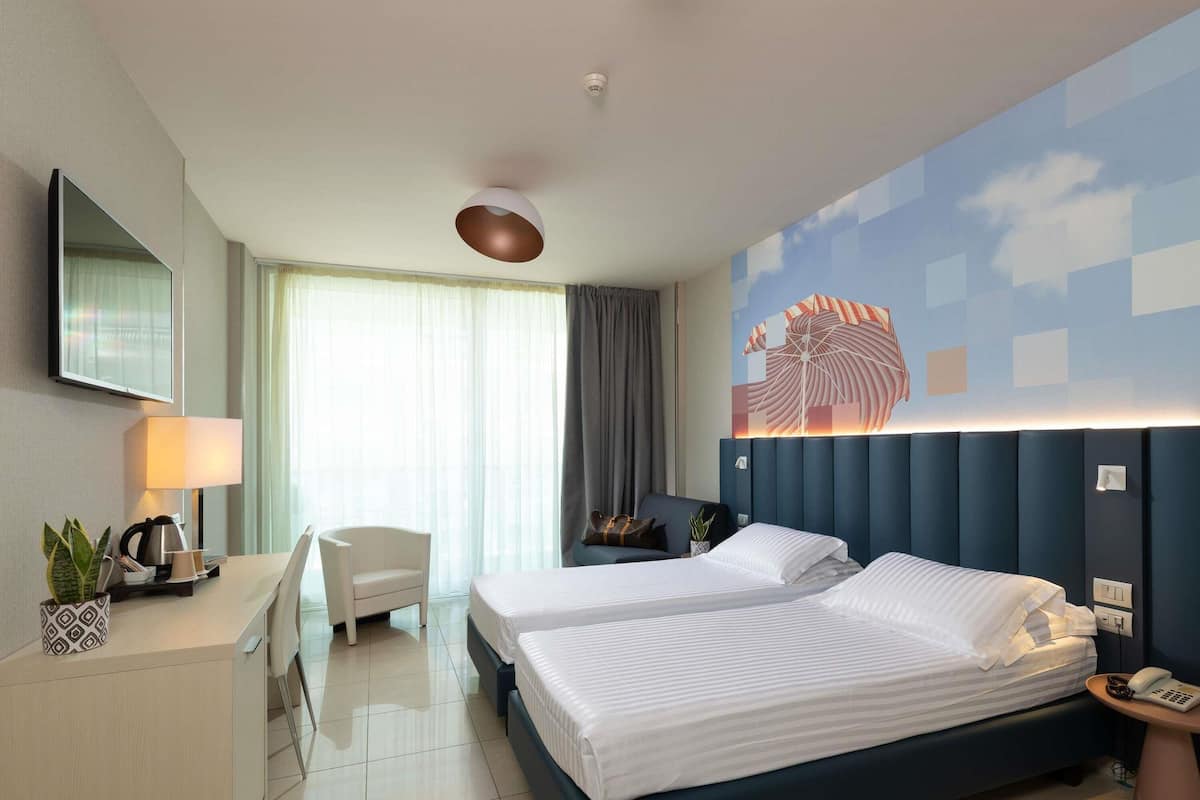 غرفة سوبيريور - سريران فرديان منفصلان - بشرفة - بمنظر جزئي للبحر (side sea view) | ألحفة محشوة بالريش وأسرّة بطبقة علوية مريحة وميني بار وخزنة داخل الغرفة