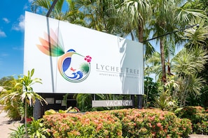Un anuncio de apartamentos LYCHEE TREE con un letrero que dice 'VACANCIA'.
