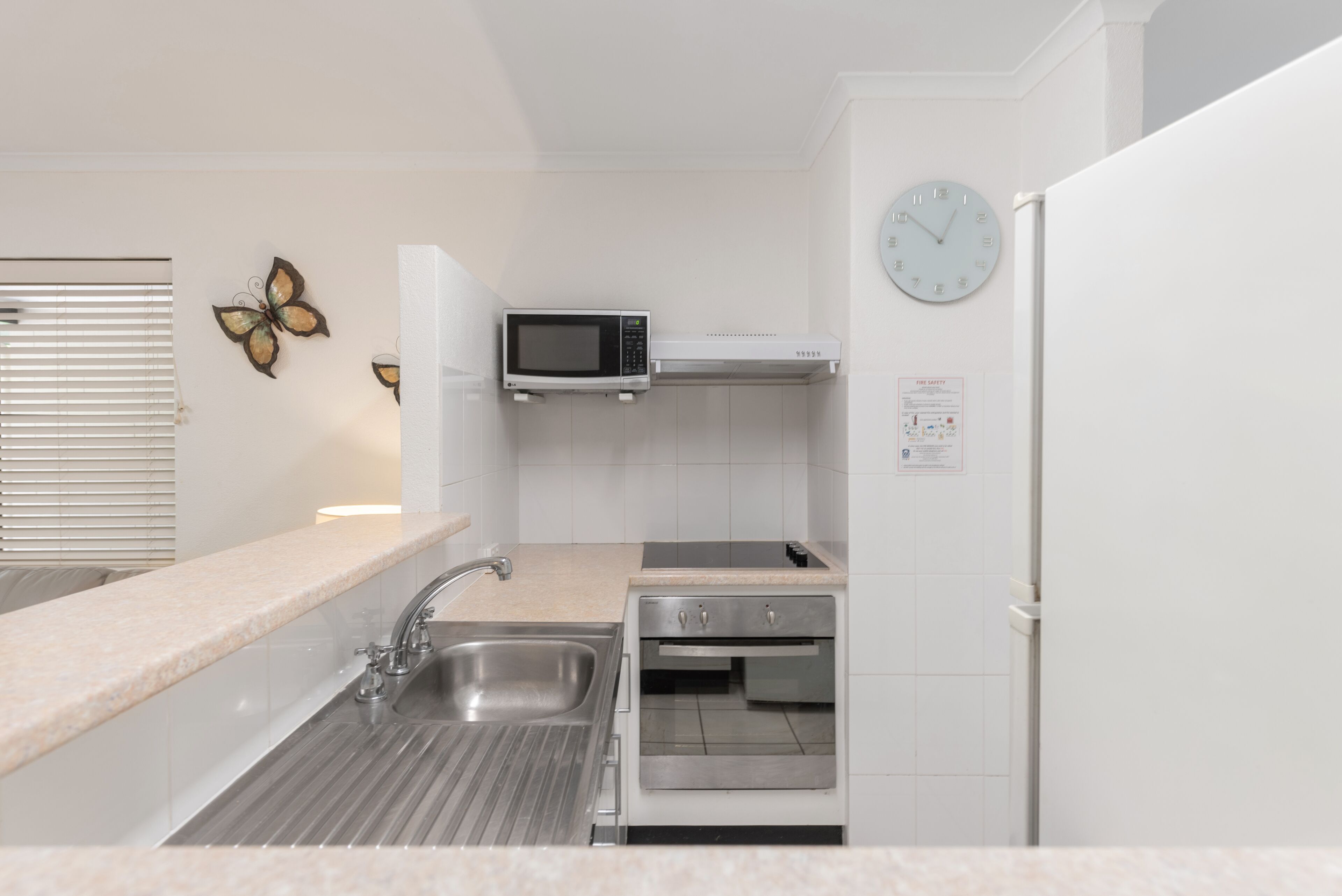A modern kitchen with a built-in microwave, oven, and sink.