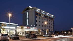 Un hotel de diseño moderno, que cuenta con un llamativo letrero 'BLU ARENA', el restaurante 'Davenport' y un estacionamiento con varios coches.