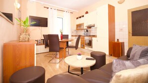 A compact living space with a dining area, kitchenette, and seating area. - Divine Apartments (Dubrovnik)