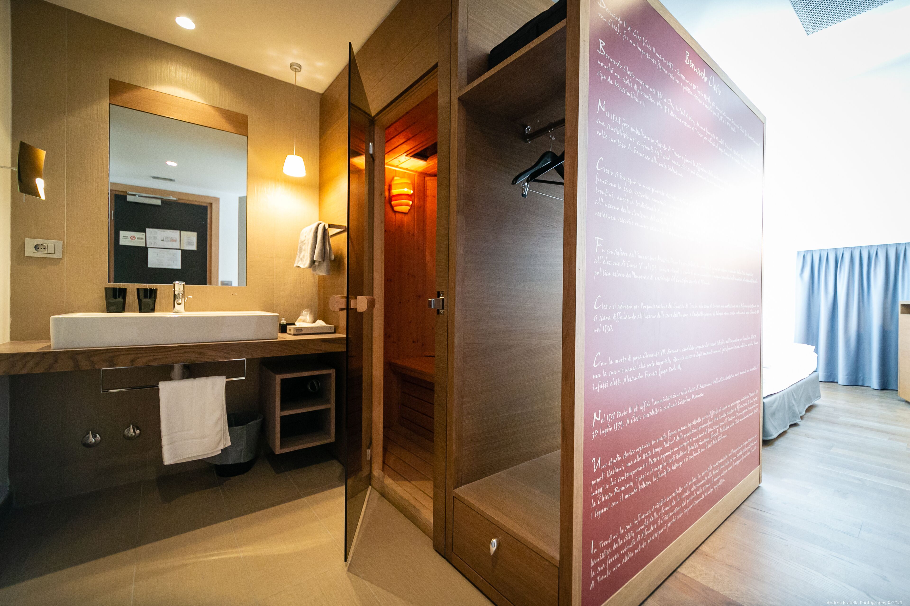 Ein modernes Badezimmer mit einem Holzlagerfläschchen, einem großen Spiegel und einer Duschkabine.