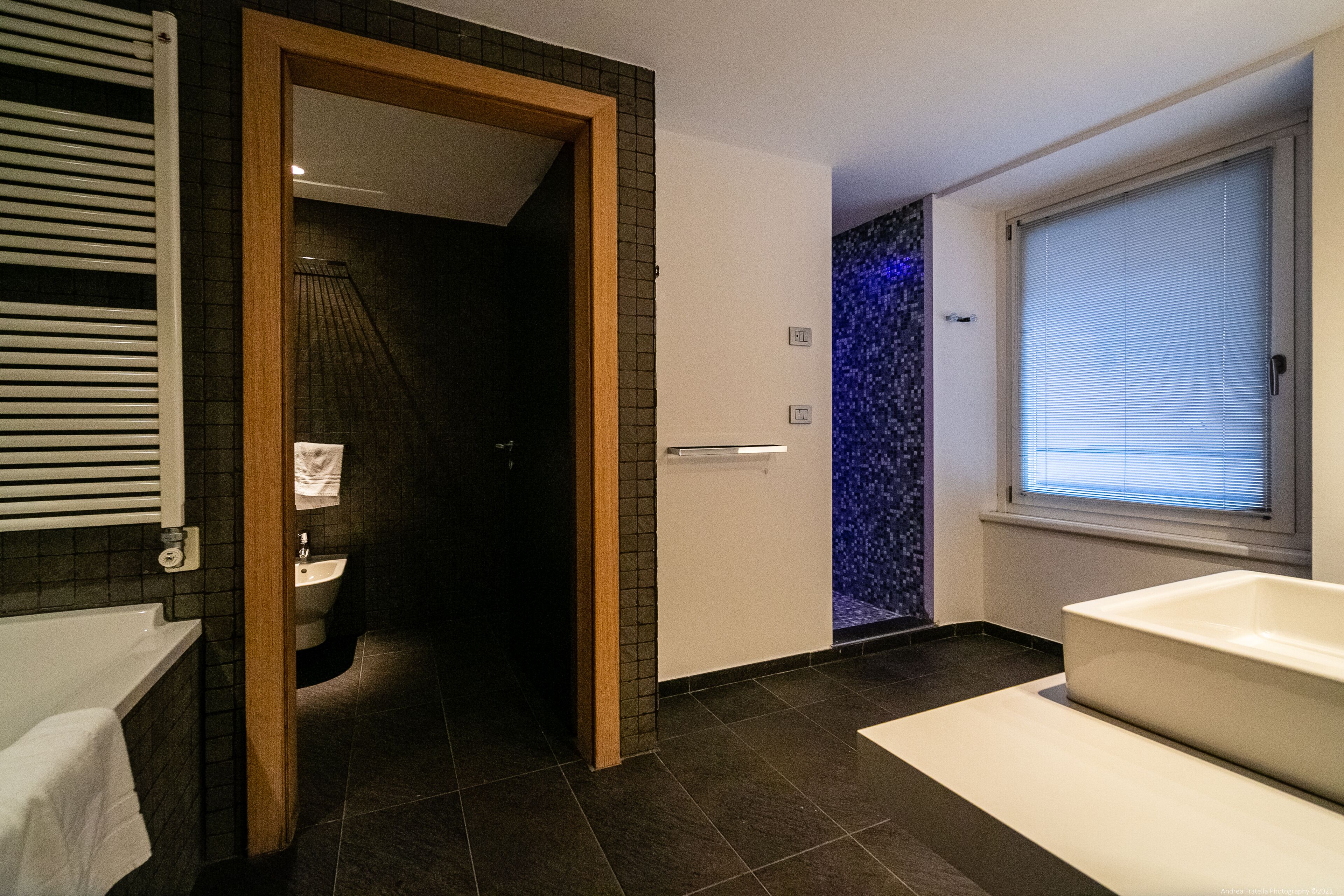 Un baño moderno con bañera, lavamanos y zona de ducha.
