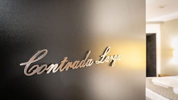 Una pared con un letrero metálico que dice 'Contrada Larga'.
