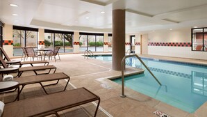Un área de piscina con sillones de descanso y una piscina.