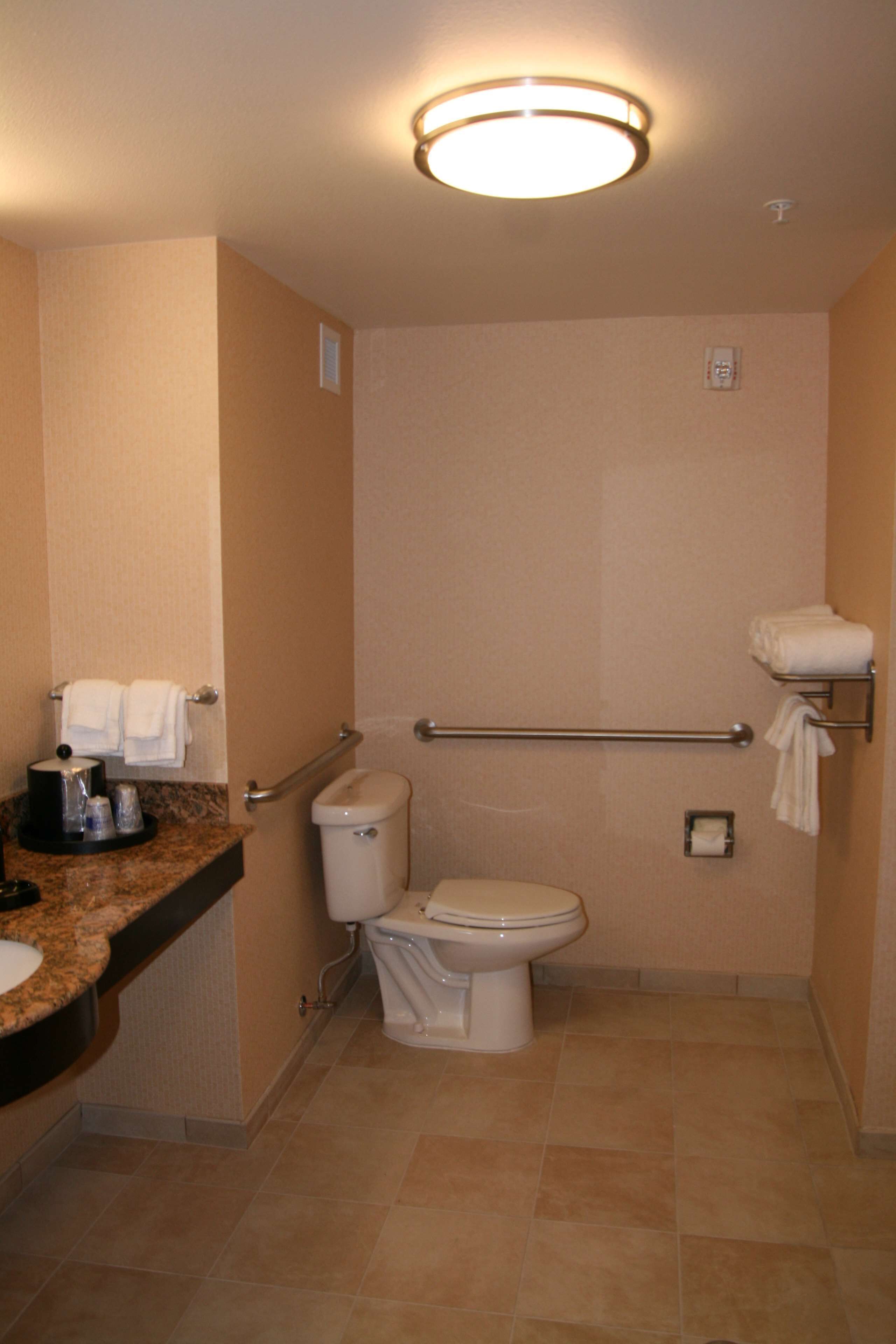 A small, compact bathroom with a toilet, a sink, and a towel rack.