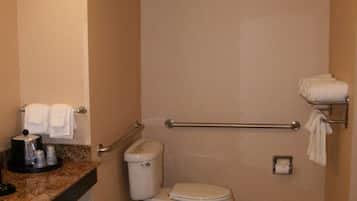 A small, compact bathroom with a toilet, a sink, and a towel rack.