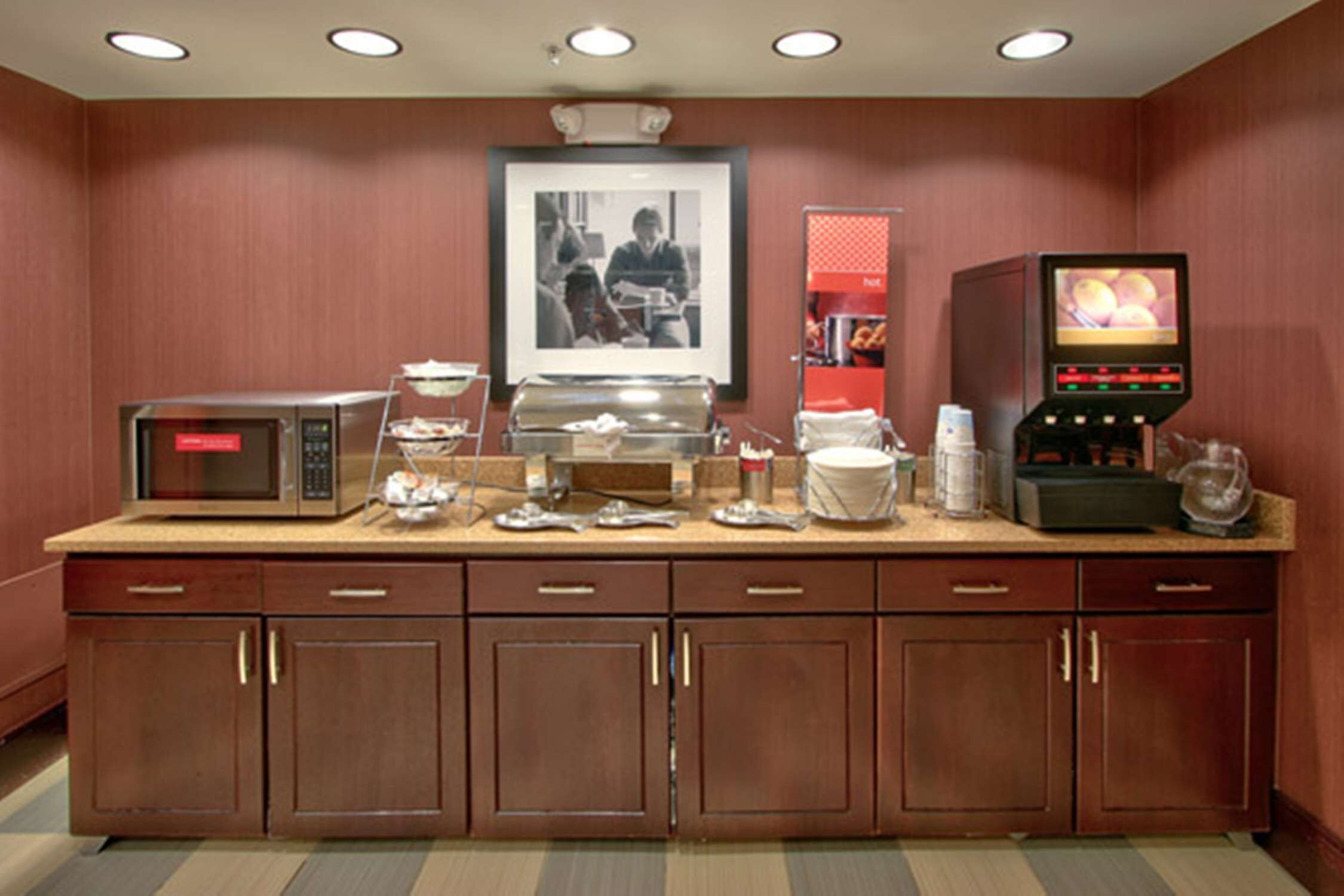 A kitchenette with a microwave, coffee maker, and a small television.