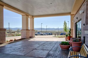 A covered parking area with a bench, potted plants, and a view of mountains. - Hampton Inn & Suites Denver/Highlands Ranch (Littleton)