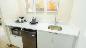 A compact kitchen with a microwave, refrigerator, sink, and coffee maker. - Hampton Inn & Suites Mission (Mission)