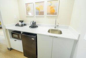 A compact kitchen with a microwave, refrigerator, sink, and coffee maker. - Hampton Inn & Suites Mission (Mission)