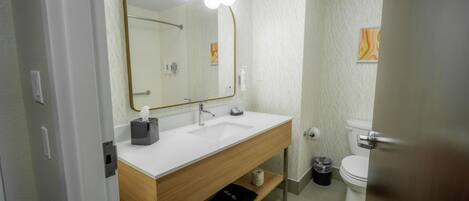 Un baño con tocador, espejo y retrete.
