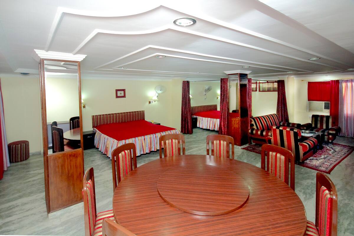Una habitación de hotel con comedor, cama y sofá.