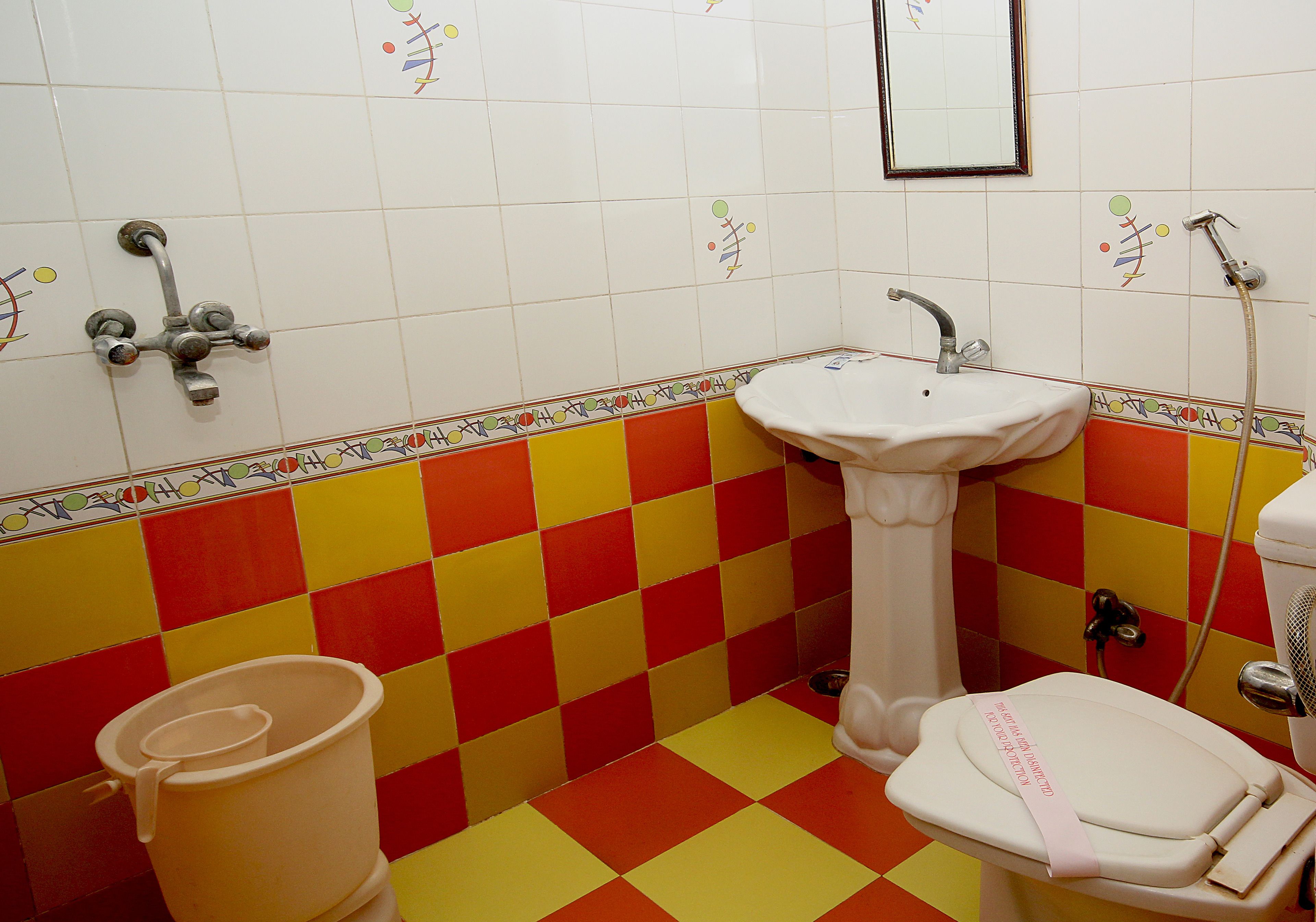 A bathroom with a checkered floor, a sink, a toilet, and a shower.
