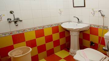 A bathroom with a checkered floor, a sink, a toilet, and a shower.