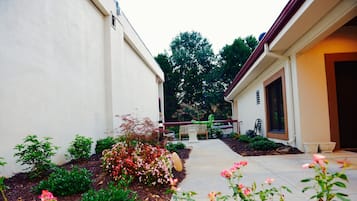 Un jardín residencial con un sendero que lleva a una casa.