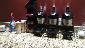 A kitchen counter with a coffee maker, a bottle of Nestle Coffee Mate, and a container of coffee creamer. - Red Roof Inn & Suites Commerce - Athens (Commerce)