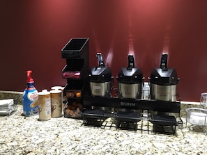 A kitchen counter with a coffee maker, a bottle of Nestle Coffee Mate, and a container of coffee creamer. - Red Roof Inn & Suites Commerce - Athens (Commerce)