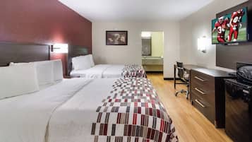 Habitación de hotel con dos camas, un escritorio, una silla, un televisor y un minibar.