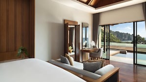 Een moderne hotelkamer met een groot bed, een zithoek, een bureau en uitzicht op de bergen.