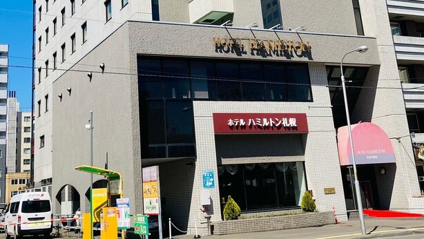 Un hôtel moderne avec une enseigne bien visible portant l’inscription « HÔTEL HAMILTON ».
